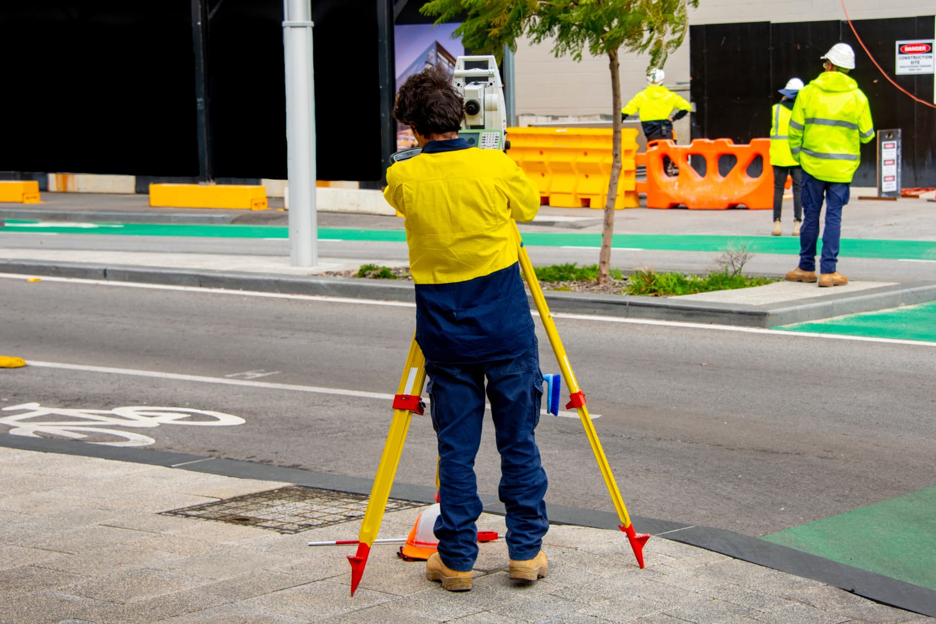 Surveyor using a total station on a street worksite